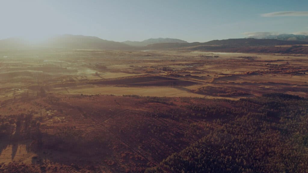 Vista aérea de terrenos en venta en Trevelin con luz de amanecer sobre el valle